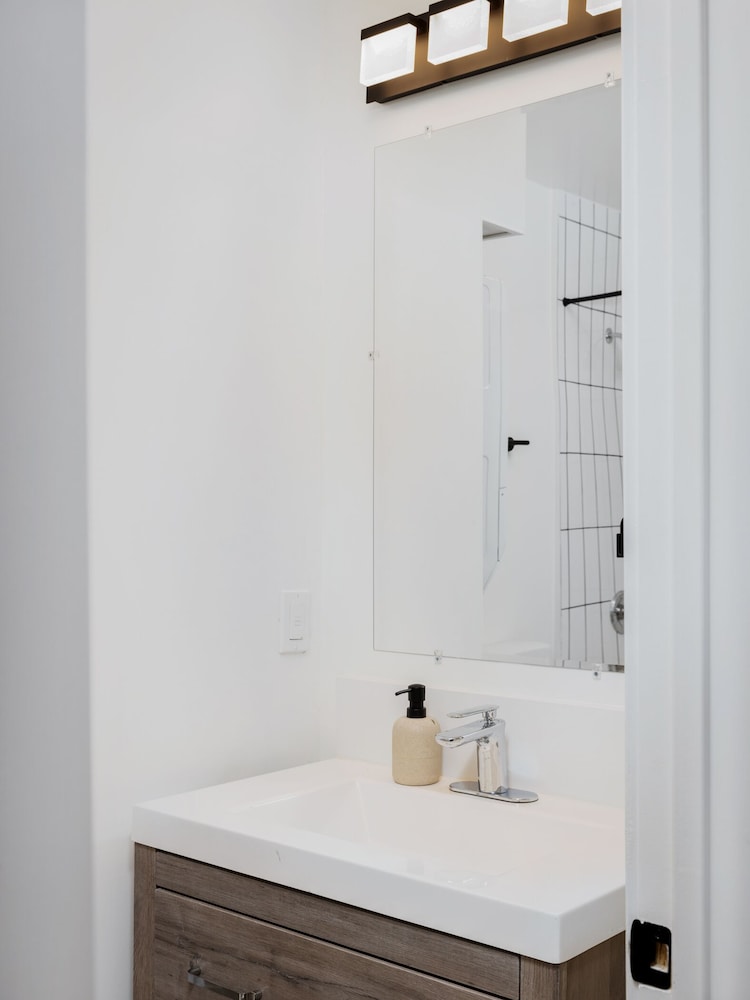 White bathroom vanity with mirror and light fixture