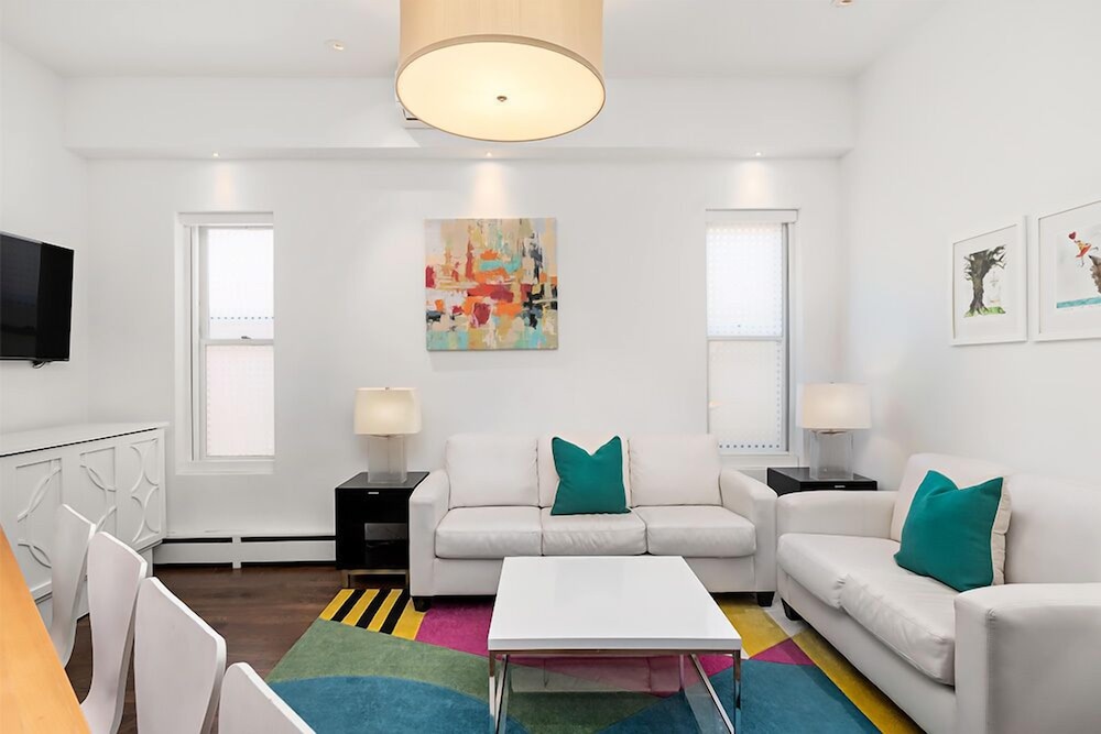 White living room with sofas and colorful rug