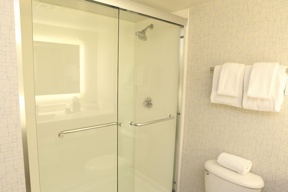 bathroom with a toilet, shower, and towel rack