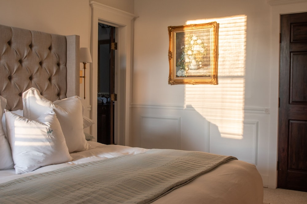 bed with white pillows and a brown door in the background