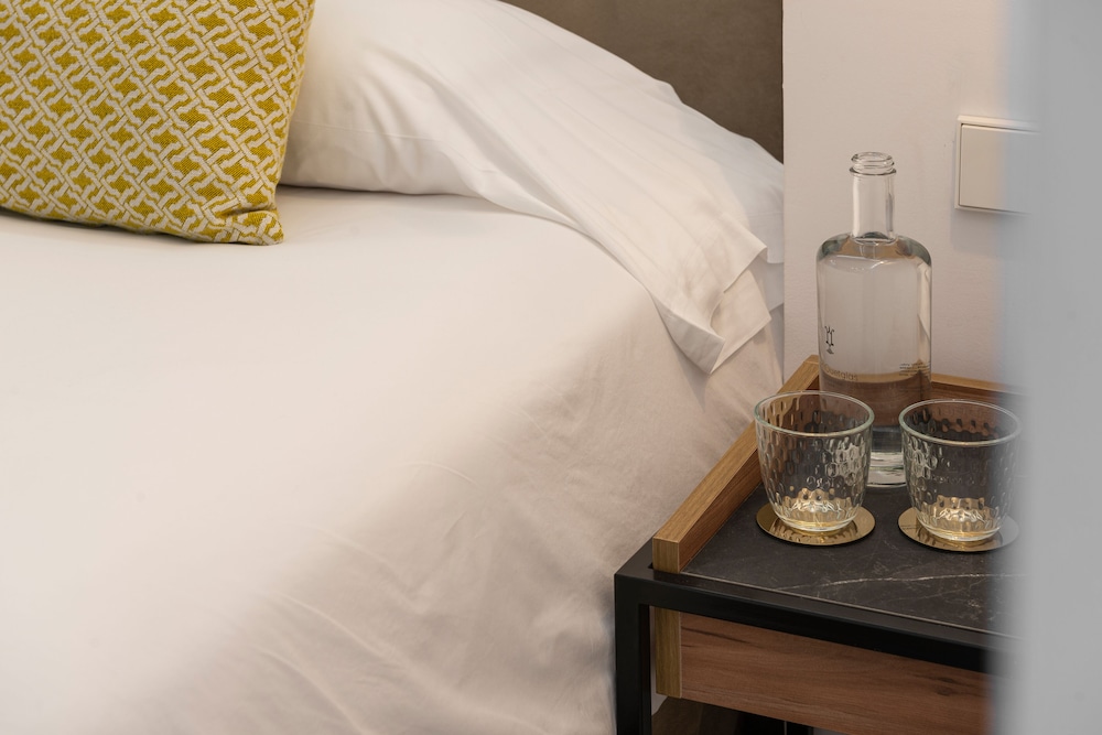 shot of a bed with white sheets and yellow pillows