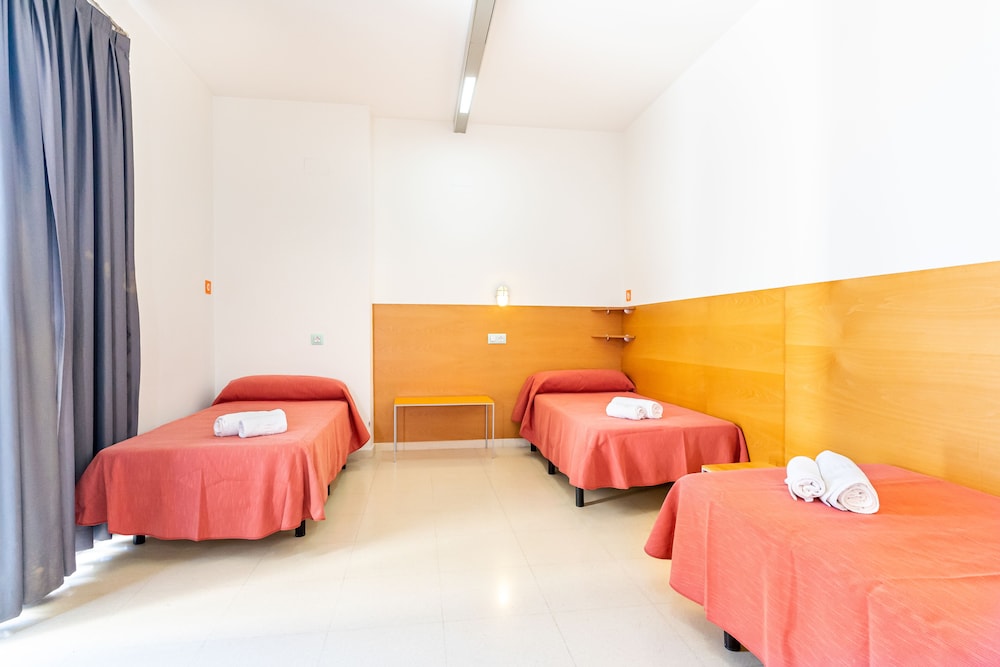 Una cama en habitación compartida con baño compartido.