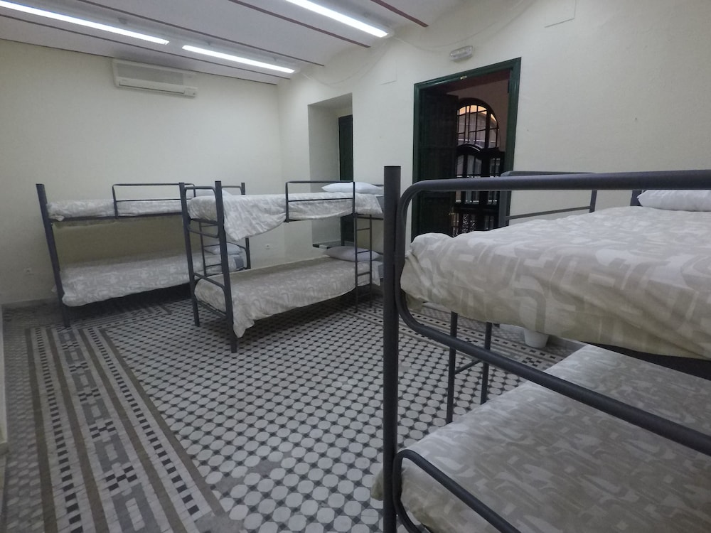 Cama en dormitorio mixto de 6 camas con baño compartido