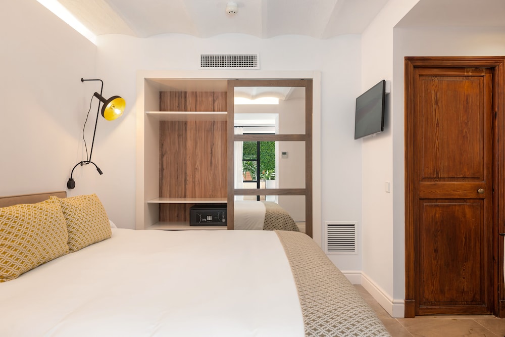 hotel room with a bed, desk, and television