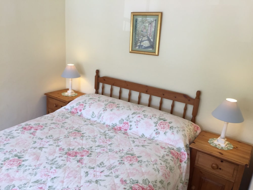 bed with a floral comforter and two lamps on either side of the bed