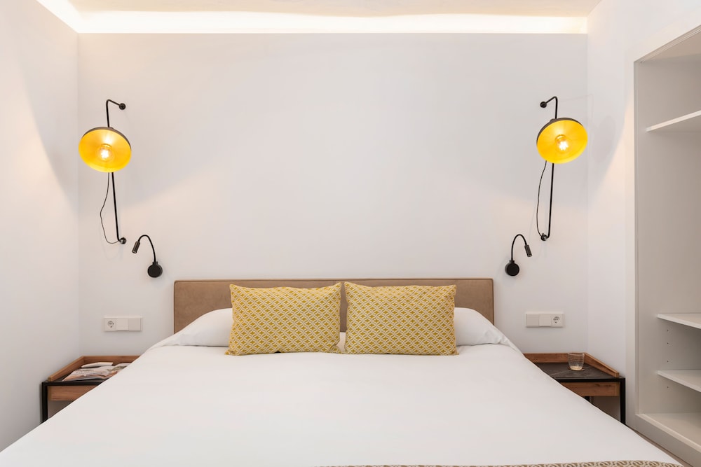 bedroom with a bed and two lamps on the wall