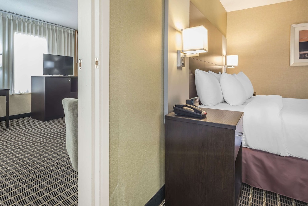 hotel room with a bed, desk, and television