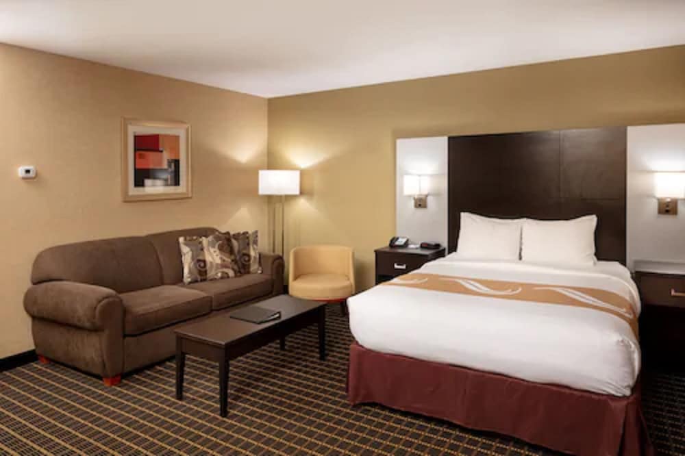 hotel room with a bed, couch and coffee table