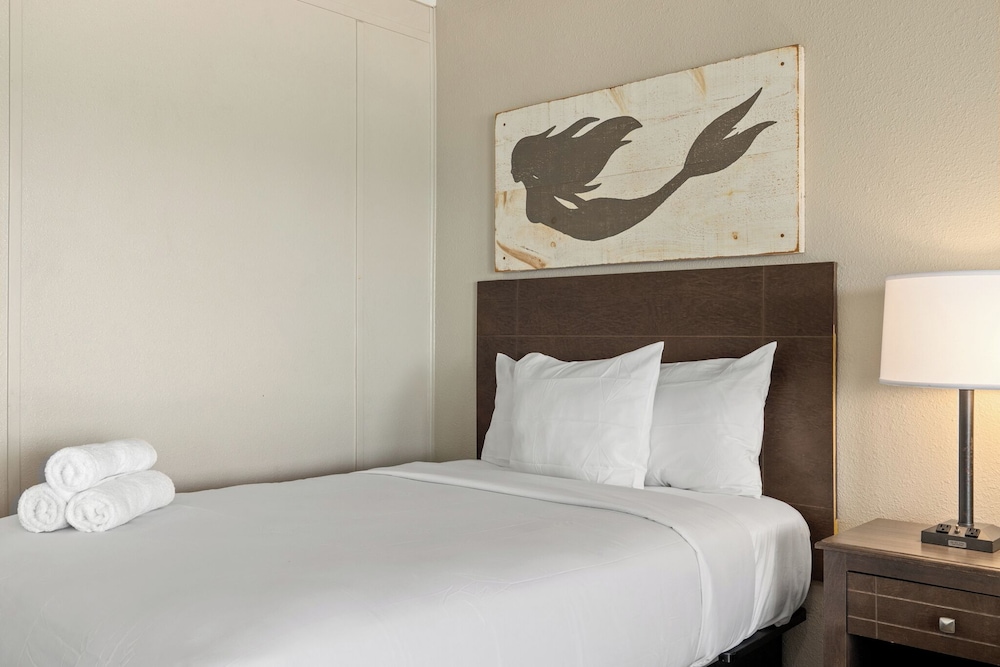 Suíte de 1 quarto com três camas de casal e sofá-cama, frente à praia no térreo.