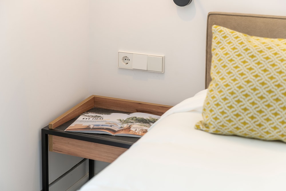 bed with a yellow pillow and a magazine on it
