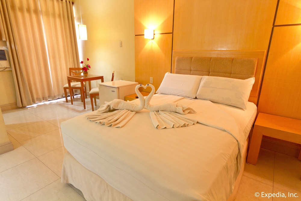 hotel room with towels on the bed and two chairs