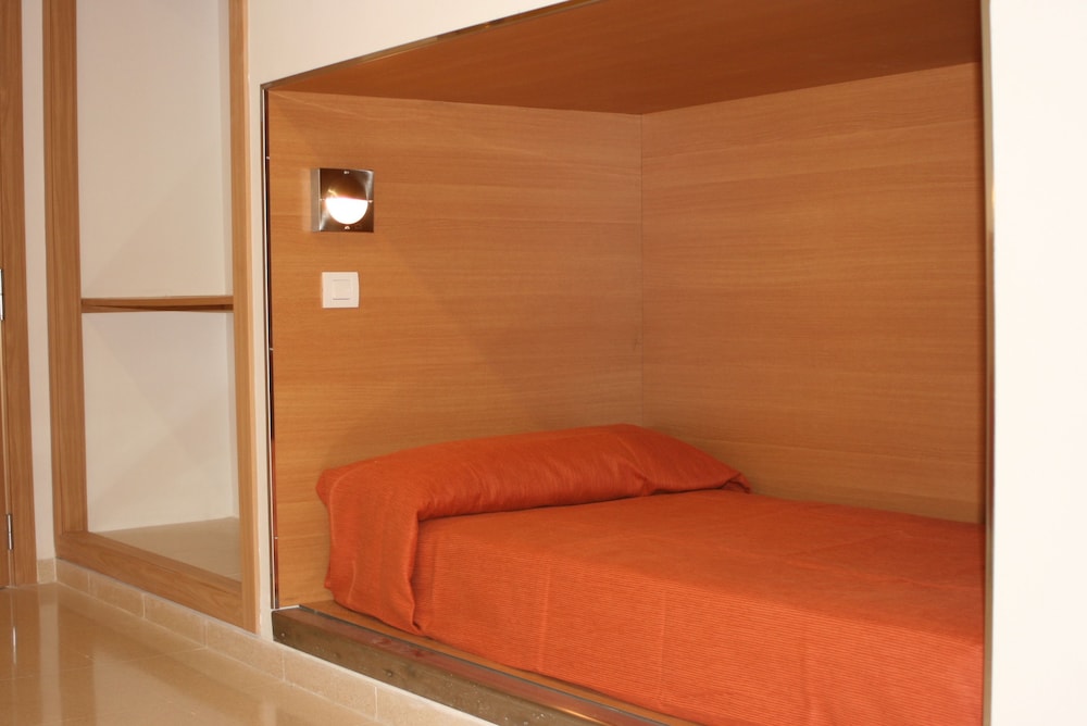 Una cama en habitación compartida con baño compartido.