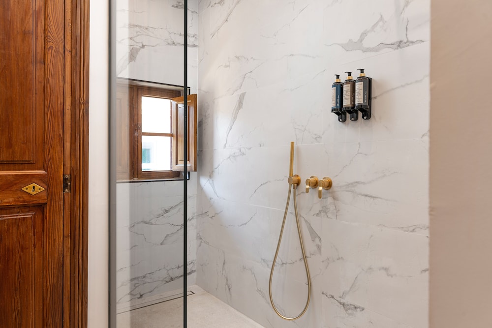 walk - in shower with marble walls and flooring