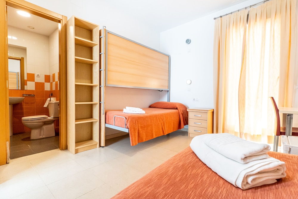 Una cama en habitación compartida con baño compartido.