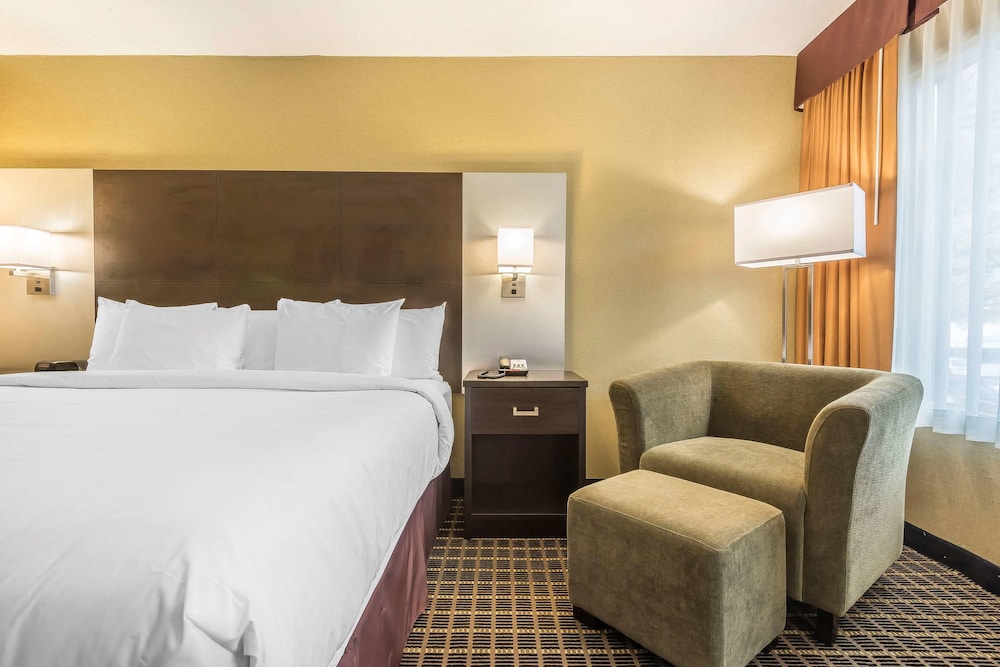hotel room with a king size bed and two chairs