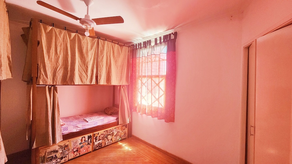 Cama em dormitorio misto com 4 camas e ventilador
