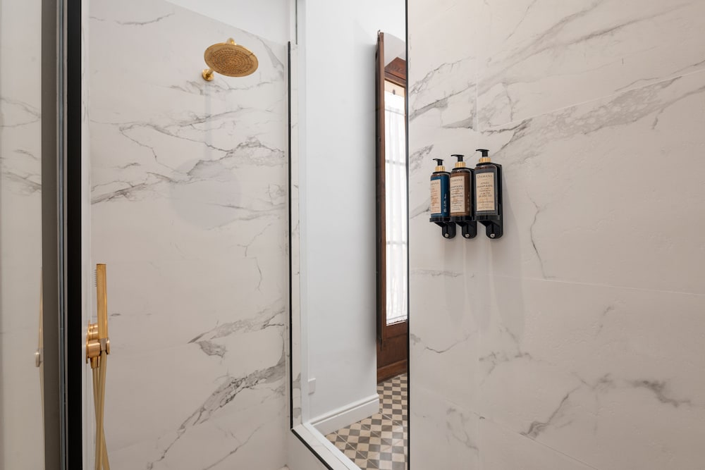 walk - in shower with marble walls and flooring