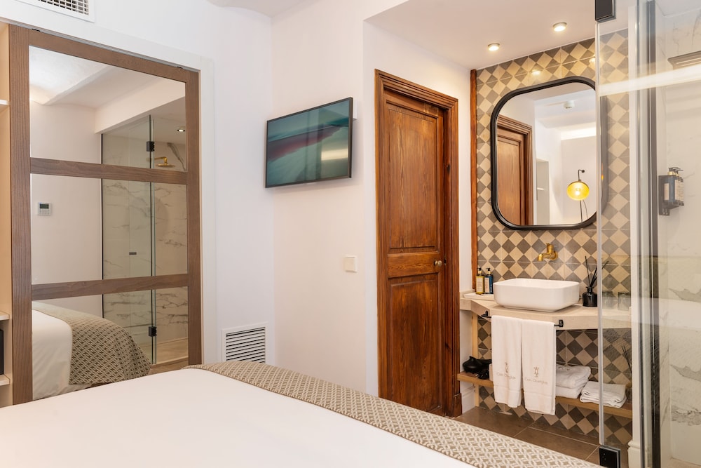 bathroom with a shower, sink, mirror and bed