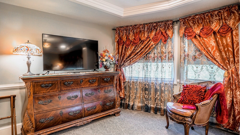 Dresser with TV, lamp, and chair by window