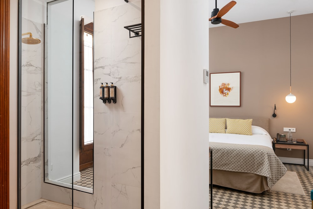 bathroom with a shower and a bed in the corner