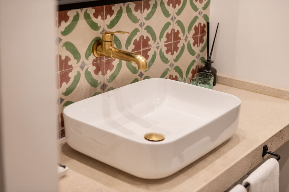 white sink with a gold faucet on it