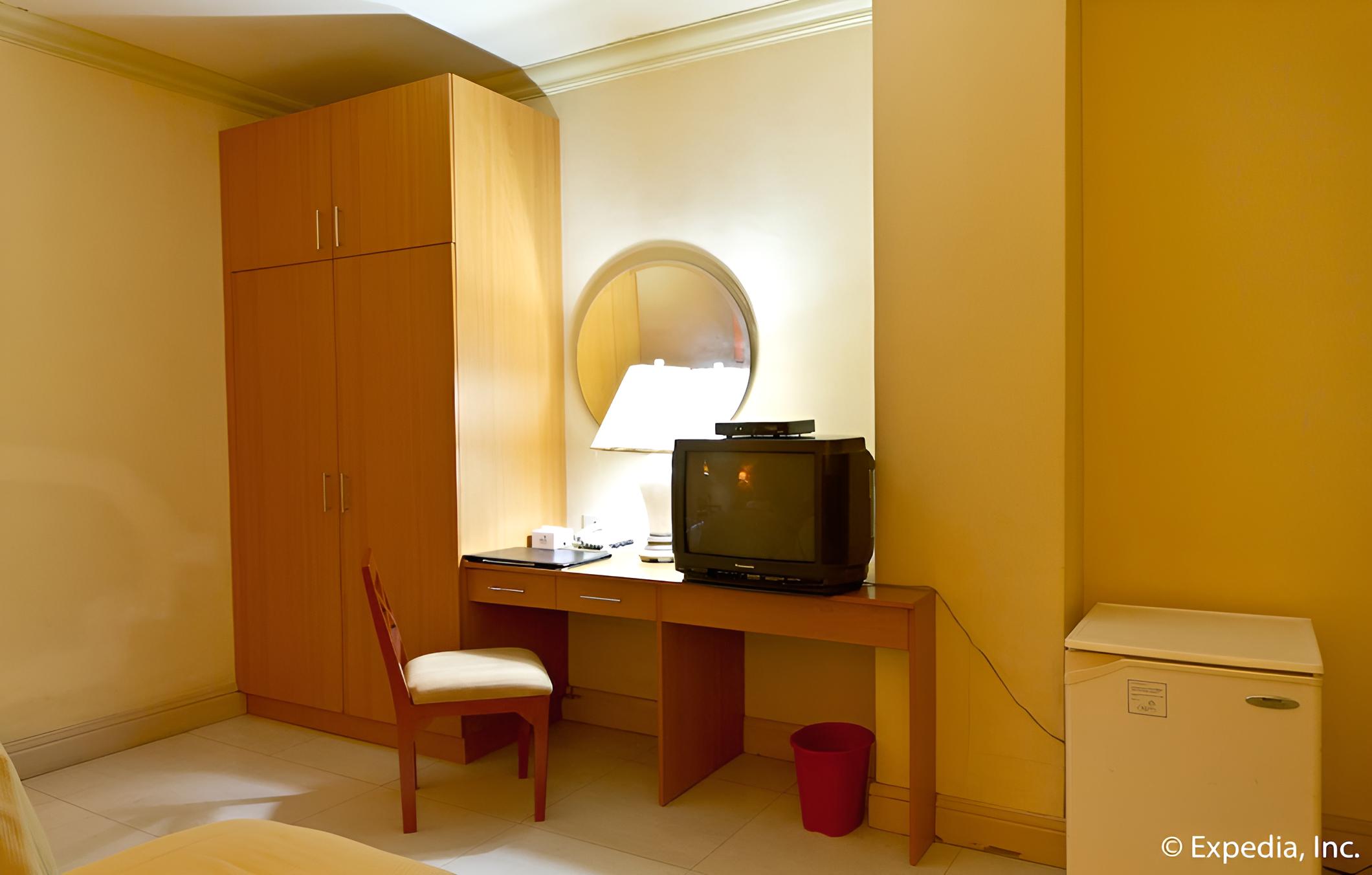 hotel room with the television and desk in it?